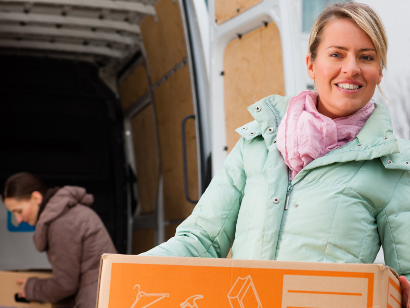 A woman loading a box into a van on oving Day